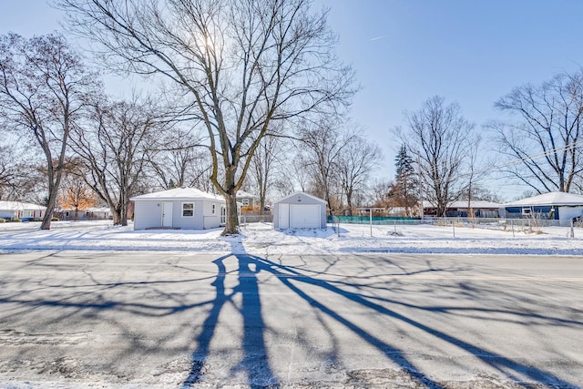 yard covered in snow featuring an outbuilding and fence