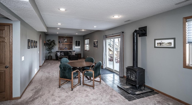 19288 Evenston Dr, Farmington, MN 55024 - carpeted dining space featuring baseboards, a wood stove, a textured ceiling, recessed lighting, and tile patterned floors