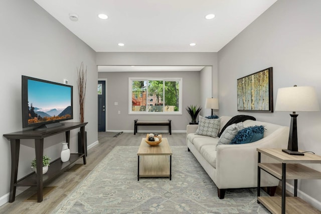 living area featuring light wood-style floors, baseboards, and recessed lighting