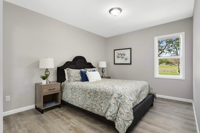 bedroom featuring light wood-style flooring and baseboards