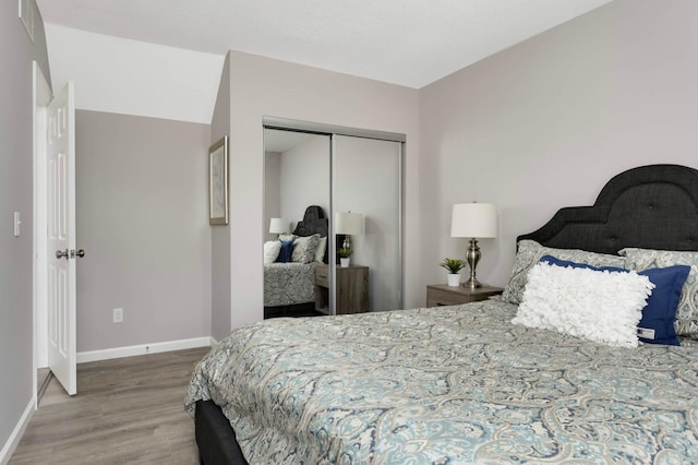 bedroom featuring wood finished floors, a closet, and baseboards