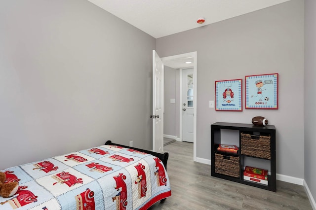 bedroom with wood finished floors and baseboards