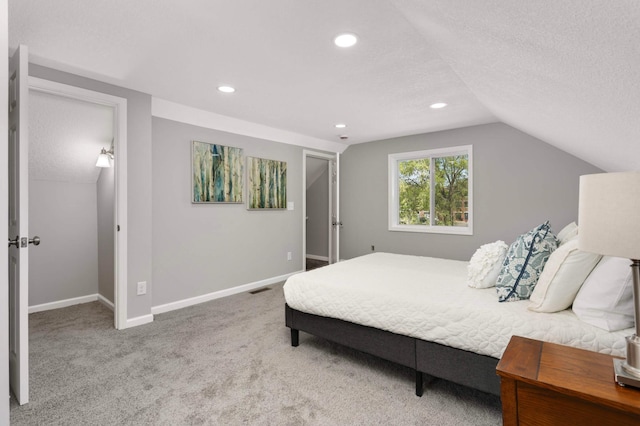 carpeted bedroom with baseboards, lofted ceiling, a textured ceiling, recessed lighting, and a spacious closet