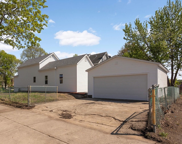 view of home's exterior featuring a garage, fence, and an outdoor structure