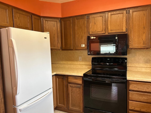 kitchen featuring light countertops, black appliances, and brown cabinets