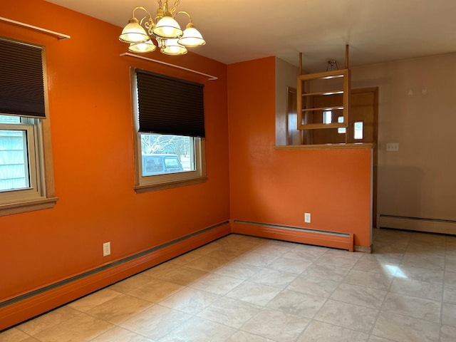 empty room featuring baseboard heating, an inviting chandelier, and plenty of natural light