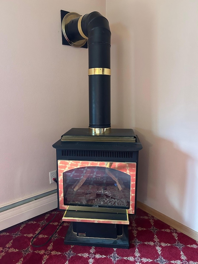 room details with a wood stove, baseboards, and carpet floors