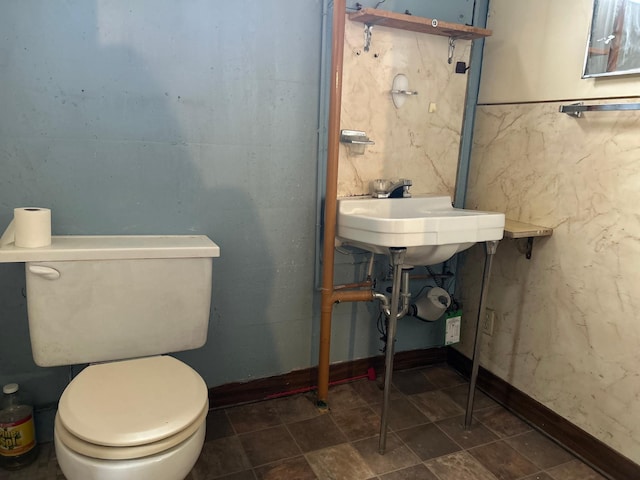 bathroom featuring toilet and baseboards