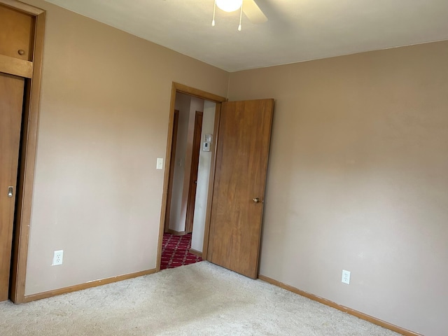unfurnished bedroom featuring baseboards, a ceiling fan, and carpet floors