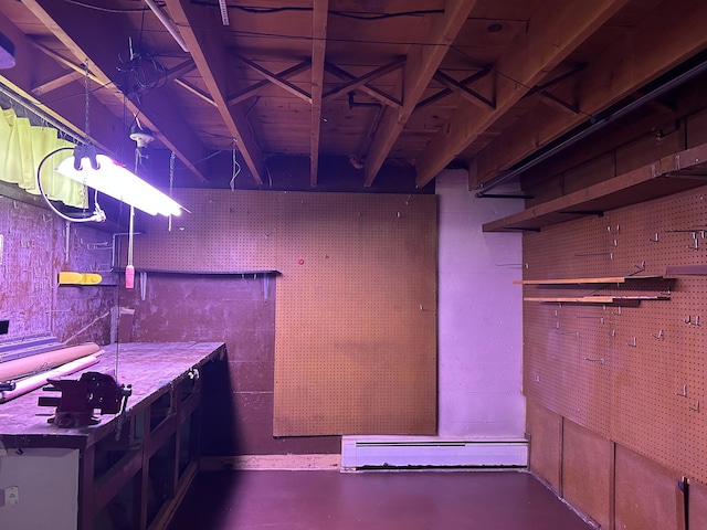 basement with a baseboard radiator and a workshop area