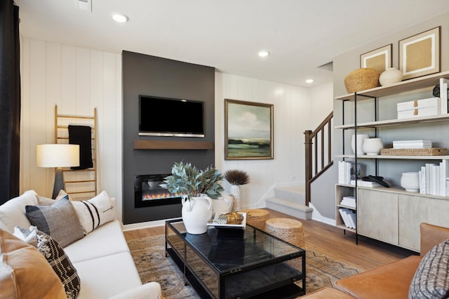 15071 Athgoe Dr, Rosemount, MN 55068 - living room with stairs, wood finished floors, a glass covered fireplace, and recessed lighting