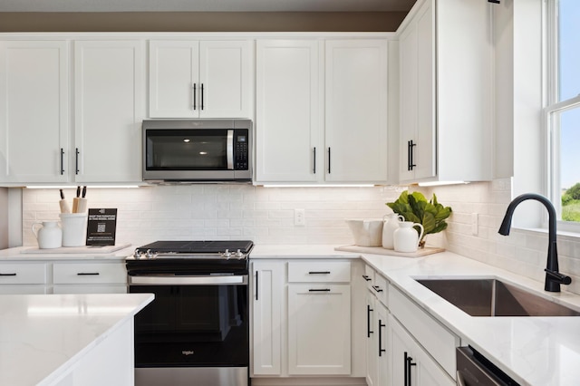 15071 Athgoe Dr, Rosemount, MN 55068 - kitchen featuring stainless steel appliances, a sink, white cabinets, light stone countertops, and backsplash