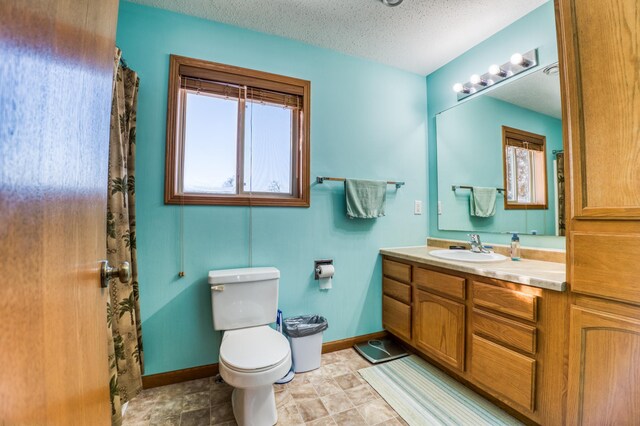 16693 Hightop Way NW, Cass Lake, MN 56633 - full bathroom with vanity, toilet, baseboards, and a textured ceiling