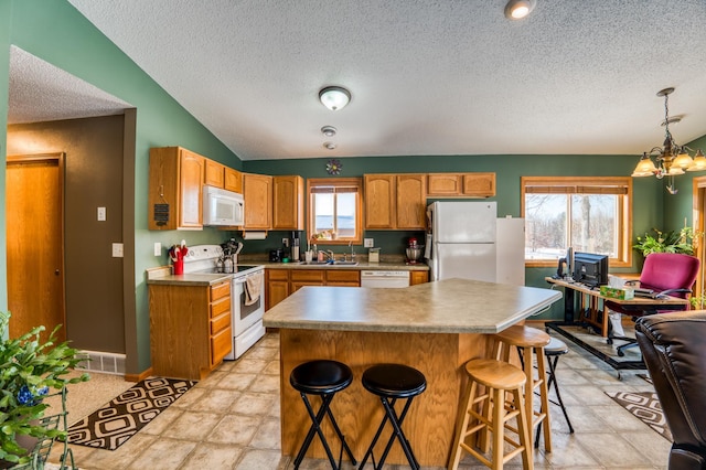 16693 Hightop Way NW, Cass Lake, MN 56633 - kitchen with white appliances, a textured ceiling, a sink, a chandelier, and a breakfast bar