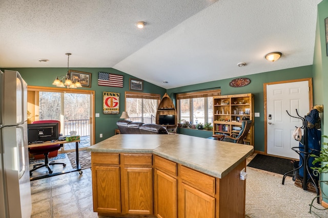 16693 Hightop Way NW, Cass Lake, MN 56633 - kitchen featuring freestanding refrigerator, open floor plan, lofted ceiling, a desk, and a textured ceiling