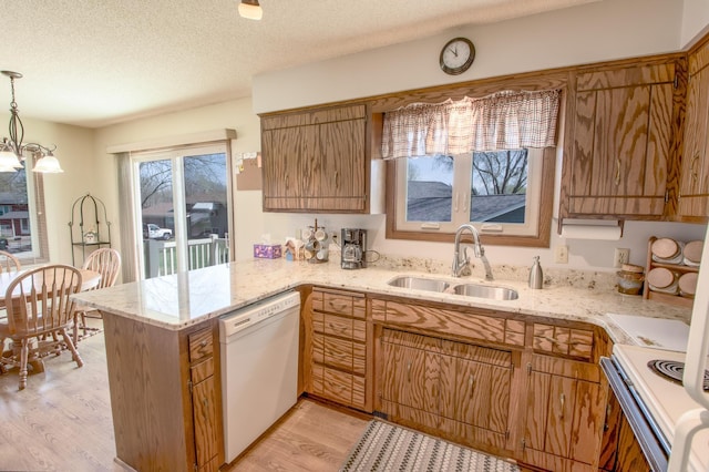 36 Ben Nevis Ln, Waite Park, MN 56387 - kitchen featuring decorative light fixtures, a sink, a peninsula, light wood-style floors, and white appliances
