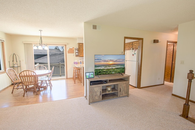 36 Ben Nevis Ln, Waite Park, MN 56387 - dining area featuring visible vents, light carpet, baseboards, a textured ceiling, and a notable chandelier