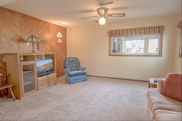 36 Ben Nevis Ln, Waite Park, MN 56387 - living area featuring wooden walls, ceiling fan, a textured ceiling, carpet, and visible vents