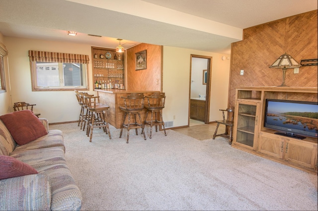 36 Ben Nevis Ln, Waite Park, MN 56387 - carpeted living area with a bar, baseboards, wooden walls, and visible vents