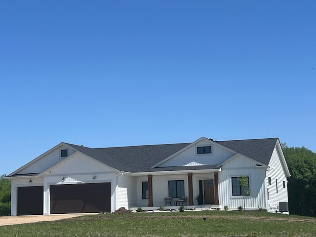 2038 Legacy Dr, Faribault, MN 55021 - modern farmhouse style home featuring covered porch, a garage, a front lawn, driveway, and a shingled roof