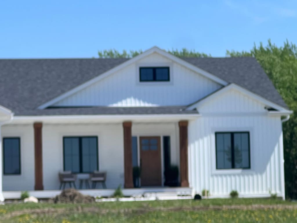2038 Legacy Dr, Faribault, MN 55021 - back of house featuring covered porch, roof with shingles, and board and batten siding