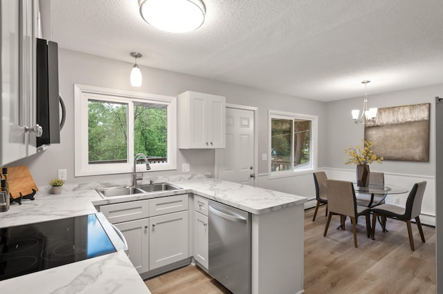 21485 Inwood Ave N, Forest Lake, MN 55025 - kitchen featuring stainless steel dishwasher, a sink, a textured ceiling, light wood finished floors, and a peninsula