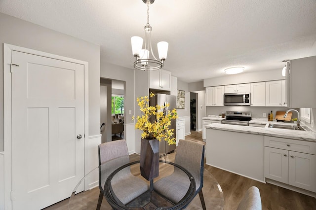 21485 Inwood Ave N, Forest Lake, MN 55025 - dining area featuring dark wood-style flooring, a chandelier, and a textured ceiling
