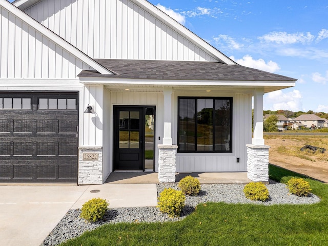 25882 Emerson Ct, Wyoming, MN 55092 - doorway to property featuring covered porch, roof with shingles, an attached garage, driveway, and board and batten siding