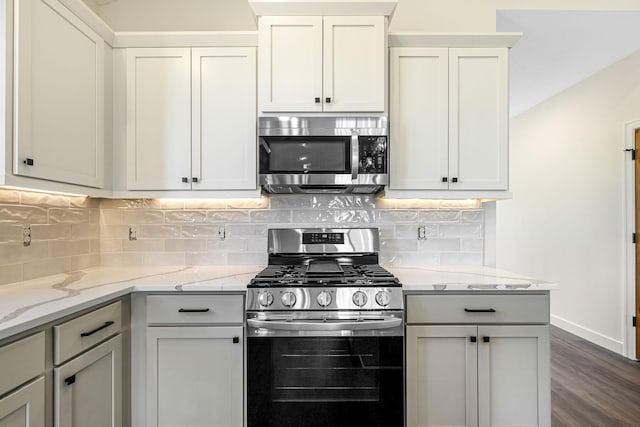 25882 Emerson Ct, Wyoming, MN 55092 - kitchen with baseboards, light stone counters, appliances with stainless steel finishes, and decorative backsplash