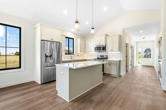 25882 Emerson Ct, Wyoming, MN 55092 - kitchen with stainless steel appliances, tasteful backsplash, wood finished floors, light countertops, and a kitchen island