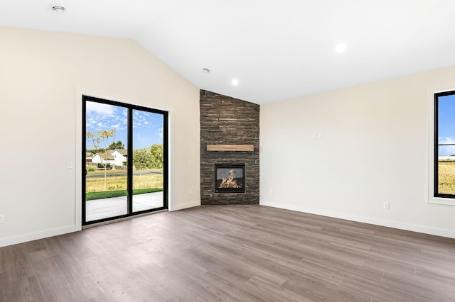 25882 Emerson Ct, Wyoming, MN 55092 - unfurnished living room with baseboards, a stone fireplace, and wood finished floors
