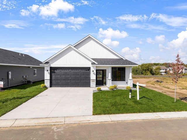 25882 Emerson Ct, Wyoming, MN 55092 - modern inspired farmhouse featuring an attached garage, concrete driveway, a front lawn, and stone siding