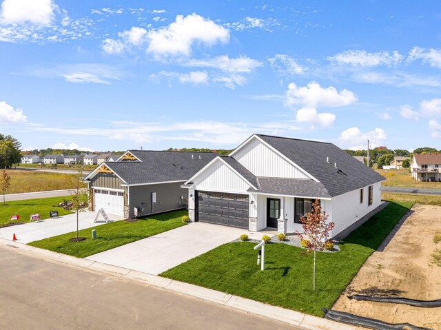 25882 Emerson Ct, Wyoming, MN 55092 - modern farmhouse style home featuring a garage, a shingled roof, board and batten siding, concrete driveway, and a front yard