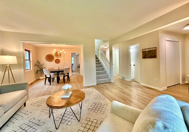 809 Wagon Wheel Trl, Mendota Heights, MN 55120 - living area with visible vents, an inviting chandelier, baseboards, stairway, and light wood-style flooring