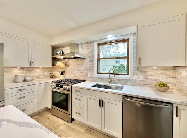 809 Wagon Wheel Trl, Mendota Heights, MN 55120 - kitchen featuring light wood-style floors, wall chimney exhaust hood, a sink, backsplash, and stainless steel appliances
