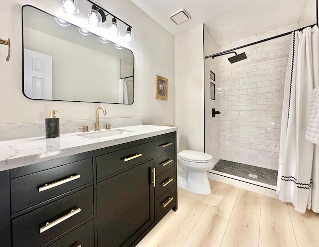 809 Wagon Wheel Trl, Mendota Heights, MN 55120 - bathroom with vanity, toilet, tiled shower, and wood finished floors
