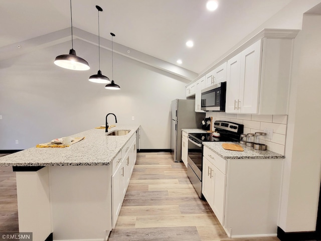 kitchen featuring a sink, light wood-style flooring, stainless steel appliances, a peninsula, and lofted ceiling