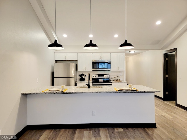 kitchen with white cabinets, light stone counters, stainless steel appliances, baseboards, and tasteful backsplash