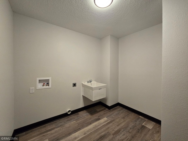 washroom with laundry area, dark wood-style flooring, a textured ceiling, electric dryer hookup, and hookup for a washing machine