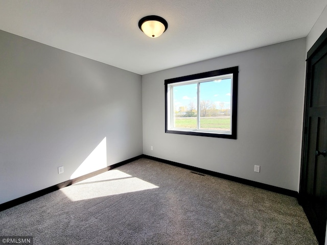 spare room featuring baseboards, carpet flooring, and visible vents