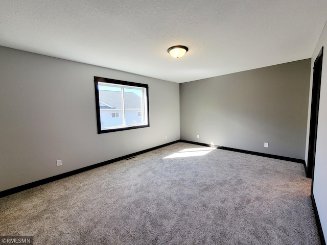 carpeted empty room with baseboards