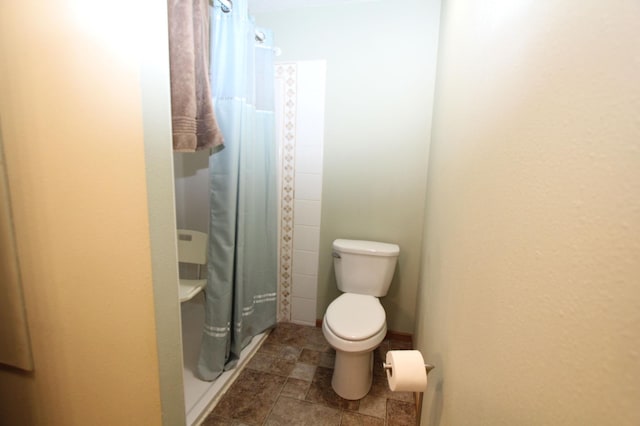 932 Spruce Ave S, Thief River Falls, MN 56701 - bathroom with curtained shower, stone finish floor, and toilet