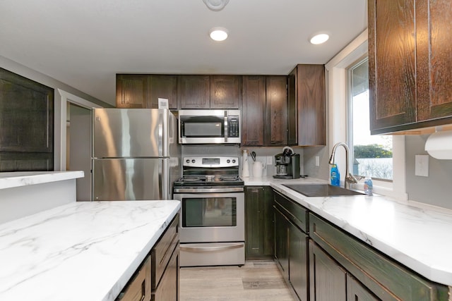 43 Blue Stem Rd, Shetek Twp, MN 56175 - kitchen featuring appliances with stainless steel finishes, a sink, light stone counters, light wood-style floors, and dark brown cabinets