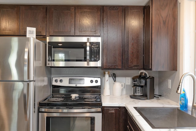 43 Blue Stem Rd, Shetek Twp, MN 56175 - kitchen with stainless steel appliances, a sink, dark brown cabinets, and light stone counters