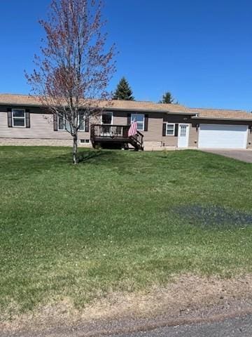 ranch-style home with a garage, a deck, driveway, and a front lawn