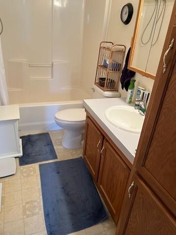 bathroom with vanity, shower / bath combo, and toilet