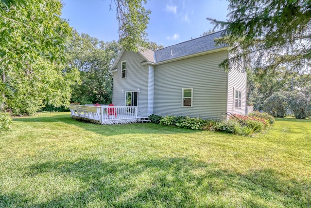 back of property with a shingled roof, a yard, and a deck