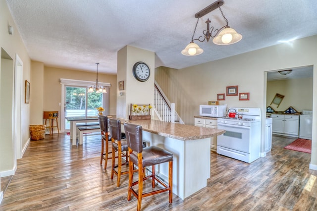 kitchen featuring white appliances, a textured ceiling, and a chandelier