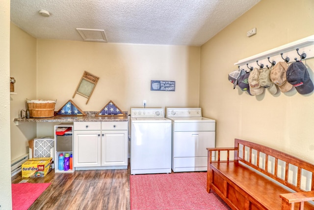 laundry room with a baseboard radiator, cabinet space, a textured ceiling, and washing machine and clothes dryer
