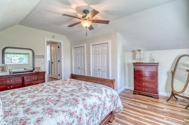 bedroom featuring baseboards, light wood-style flooring, ceiling fan, and vaulted ceiling
